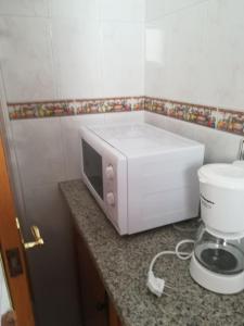 a microwave sitting on a counter next to a mixer at Ca l'Estrella II L'Estartit in L'Estartit +15 photos