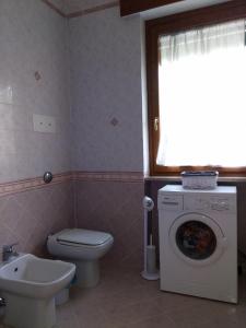 a bathroom with a toilet and a washing machine at Casa Silvia in Padenghe sul Garda