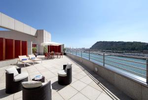 balcón con sillas, mesas y vistas al agua en Eurostars Grand Marina Hotel GL, en Barcelona