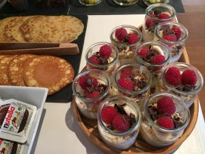 a tray of dessert dishes with raspberries and bread at Hotel La Maison de la Prade in Messanges
