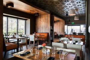 a restaurant with wooden walls and tables and chairs at Colcord Hotel Oklahoma City, Curio Collection by Hilton in Oklahoma City