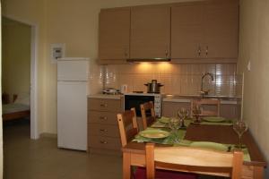 a kitchen with a table and chairs and a refrigerator at Katerina Rooms in Syvota