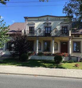 uma grande casa branca com uma varanda numa rua em Hotel Restauracja Willa Radwan em Aleksandrów Kujawski