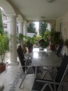 une table et des chaises sur une terrasse avec des plantes en pot dans l'établissement Apartma, à Ormoz