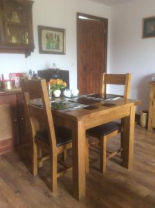 uma mesa de madeira com 2 cadeiras e uma sala de jantar em Arden Croft em Pershore