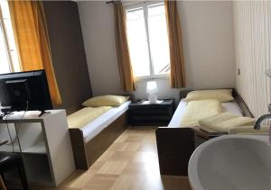 Kleines Zimmer mit 2 Betten und einem TV in der Unterkunft Bed & Breakfast Sonne in Bregenz