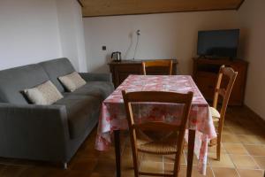 een woonkamer met een tafel en een bank bij Abeille Saint Michel in Marthod