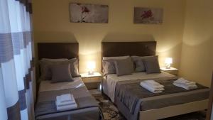 2 Betten in einem Zimmer mit 2 Lampen an der Wand in der Unterkunft Salento Al Mare in Taviano