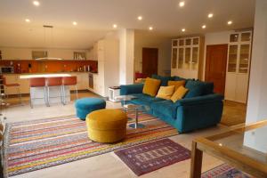 a living room with a blue couch and a kitchen at Villa Bellevue Apartment 1 Deluxe Apartment in Ossiach