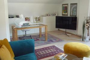 a living room with a table and a television at Villa Bellevue Apartment 1 Deluxe Apartment in Ossiach