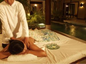 Eine Frau bekommt eine Massage auf dem Bett in der Unterkunft Nike Villas in Sanur