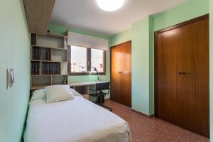 une chambre avec un lit, un bureau et une fenêtre dans l'établissement ApartUP Mestalla Home, à Valence