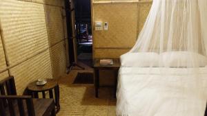 a bedroom with a bed and a table with a chair at Lanna House Lanna Hut Chiangmai in Chiang Mai