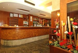 a lobby of a hotel with a bar and flowers at Hotel Villa Molinari in Collecchio