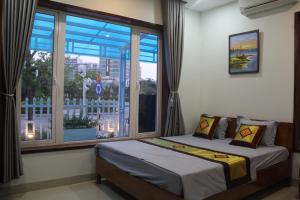 a bedroom with two beds and a large window at Ngoc Trai 01 Villa FLC Sam Son in Sầm Sơn +90 photos
