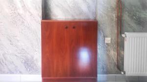 a wooden cabinet in the corner of a room at Apartments Petkovic in Soko Banja