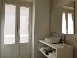 a white sink sitting under a window in a bathroom at B&B Via Cavour 32 in Syracuse