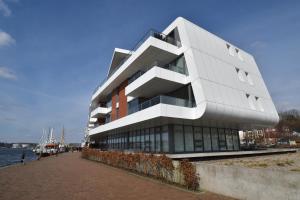 un bâtiment à côté d'une masse d'eau dans l'établissement Loft 5 - Urlaub direkt an der Förde, à Flensbourg