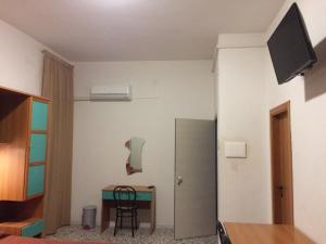 a room with a table and a chair and a television at Residence Ducale in Rodi Garganico