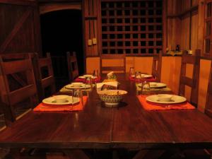 einem Holztisch mit Tellern und Geschirr darauf in der Unterkunft Vocaré Finca Agroecológica in Upala
