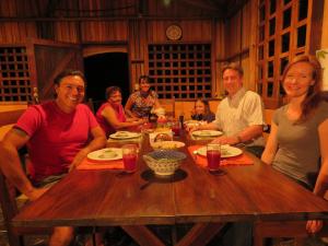 un grupo de personas sentadas alrededor de una mesa de madera en Vocaré Finca Agroecológica, en Upala