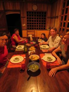 un grupo de personas sentadas alrededor de una mesa de madera en Vocaré Agroecoturismo, en Upala