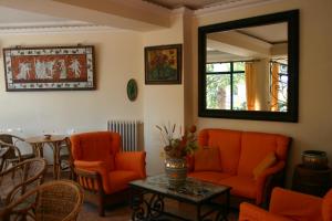 uma sala de estar com cadeiras laranja e uma mesa em Villa Gaia em Taormina