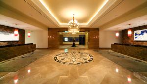 eine große Lobby mit einem Kronleuchter und einer großen Etage in der Unterkunft Nongshim Hotel in Busan