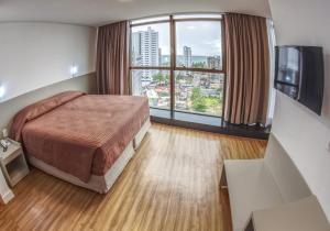 a hotel room with a bed and a window at Marante Executive Hotel in Recife