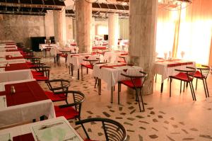 a dining room with tables and chairs and white tables and chairs at Résidence Igoudar in Agadir