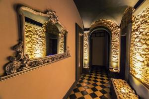 um corredor com um espelho e um piso xadrez em Hotel Pino em Lerici