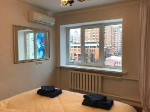 1 dormitorio con 1 cama con 2 toallas en Sunny apartment overlooking the royal village, en Kiev