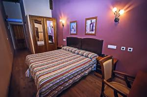Noceda del BierzoにあるHotel Rural El Verdenalの紫の部屋のベッド1台が備わるベッドルーム1室