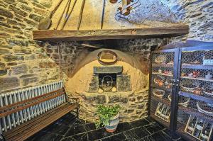 un horno de piedra con un banco delante de él en Hotel Rural El Verdenal en Noceda del Bierzo