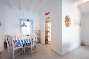 a white dining room with a table and chairs at Fonduco in Mahón