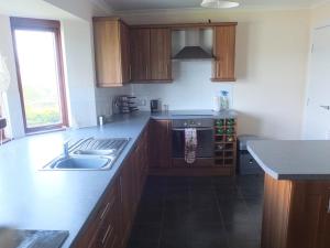 a kitchen with a sink and a stove top oven at Trefoil Holiday Home in Strachur