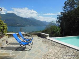 2 sillones azules junto a la piscina en Residence Giglio Comer See, en Gravedona