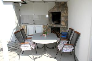 a table and chairs in a kitchen with a fireplace at Lari Home in Primošten +10 photos