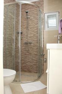a shower with a glass door in a bathroom at Lari Home in Primošten