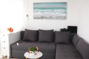 a living room with a gray couch and a table at Lari Home in Primošten
