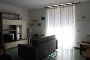 a living room with a couch and a large window at Smeraldo in Levanto