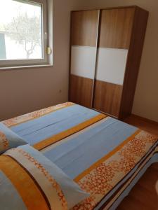 a bedroom with a bed and a wooden cabinet at Apartment Onbria Mar in Medulin