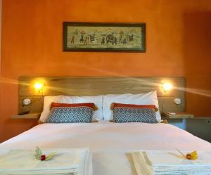 a bedroom with a large white bed with two pillows at La Goiaba B&B in Senigallia