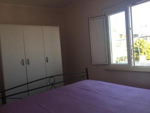 Un dormitorio con una cama y una cómoda y una ventana. en Il gabbiano, attico con terrazzo vista mare, en Peschici