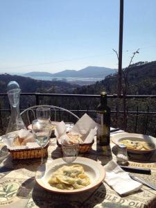 - une table avec des assiettes de nourriture et une bouteille de vin dans l'établissement Agriturismo Oliva Azzurra, à Valeriano Lunense