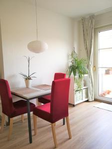 a dining room with a table and red chairs at Quiet City-Apt, 4min City-Center, 18min Fair Nürnberg!!! in Nürnberg