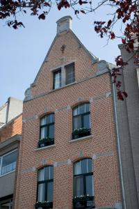 a brick building with windows on the side of it at Domus Portus in Dendermonde