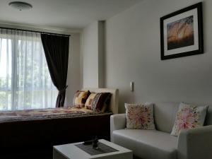 a living room with a couch and a bed at Baan Thew Lom by Meaw in Cha Am +12 photos