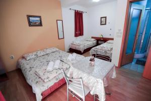 Habitación de hotel con 2 camas, mesa y sillas en Bakal Apartments, en Ohrid
