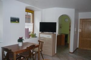 a living room with a table and a flat screen tv at Ferienwohnung Hammelburg in Hammelburg